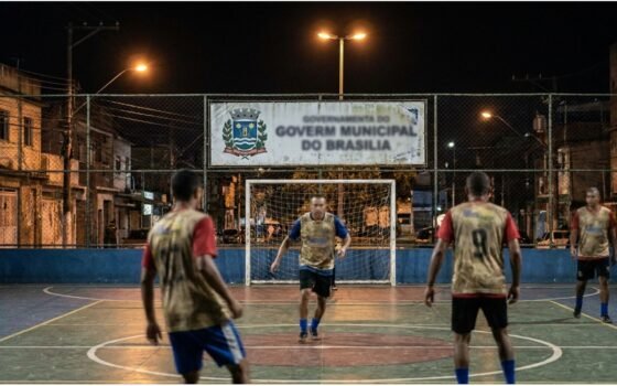 Quadra de futsal noturna com jogadores adultos em Itaquaquecetuba
