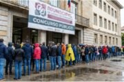Candidatos em fila para concurso público em Itaquaquecetuba, com prédio da Prefeitura ao fundo